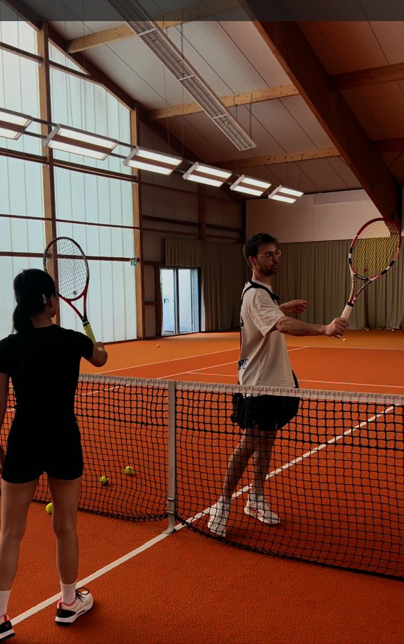 Coach demonstrating a forehand at the net during a private lesson