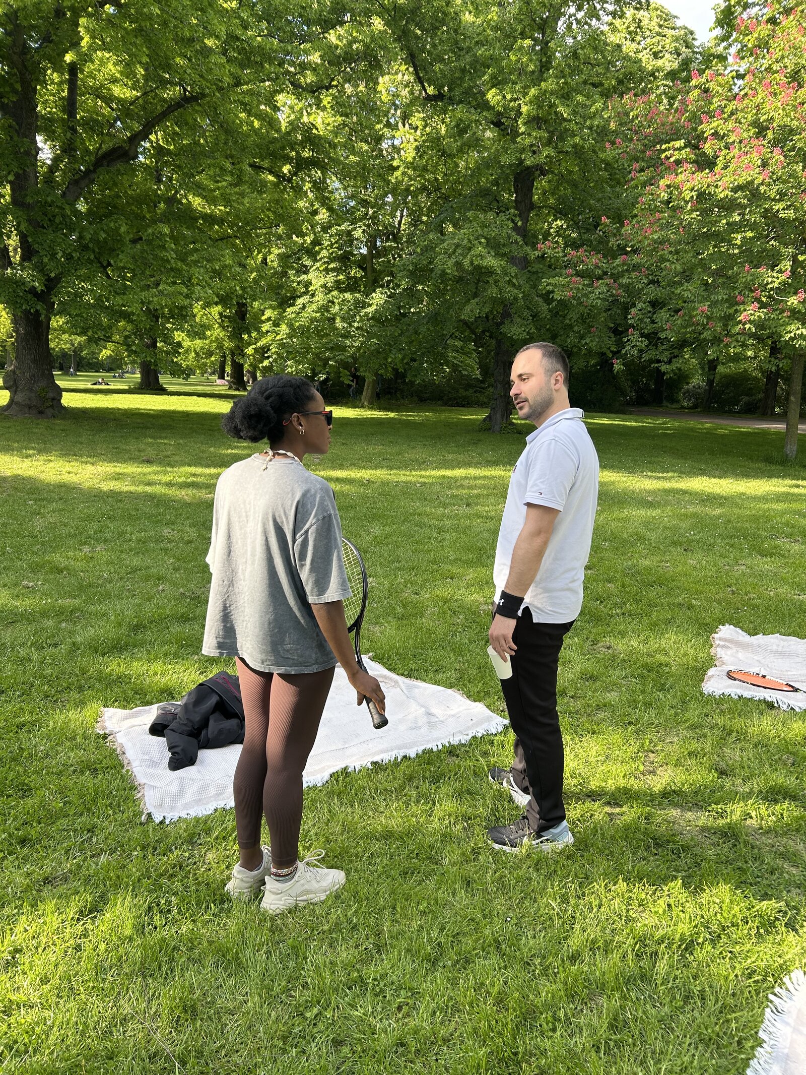 Members chatting on the grass after a tennis session in Leipzig